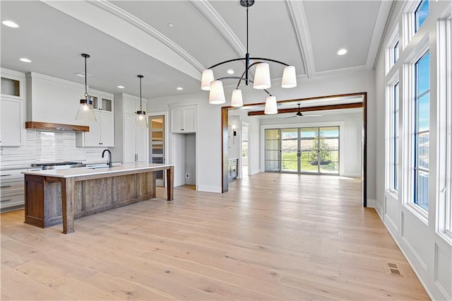 kitchen featuring a large island, white cabinets, and light wood-type flooring