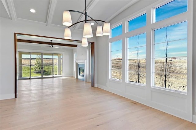 unfurnished dining area with plenty of natural light, beam ceiling, and light hardwood / wood-style flooring