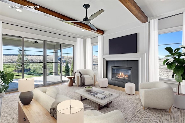 living room featuring beamed ceiling and a tiled fireplace