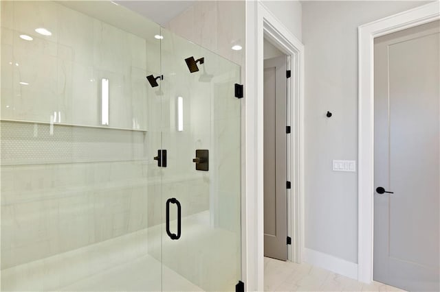 bathroom with a shower with door