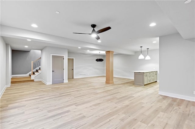 basement with ceiling fan and light hardwood / wood-style floors