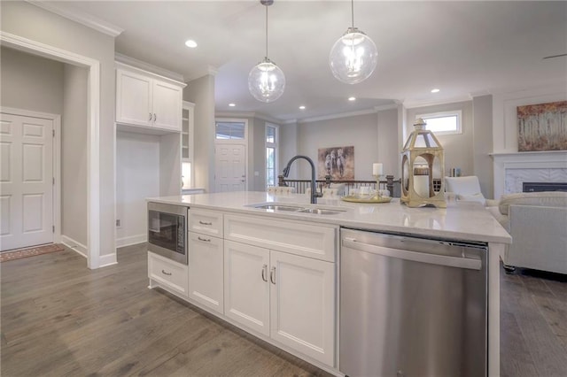 kitchen with white cabinets, stainless steel appliances, a kitchen island with sink, and sink