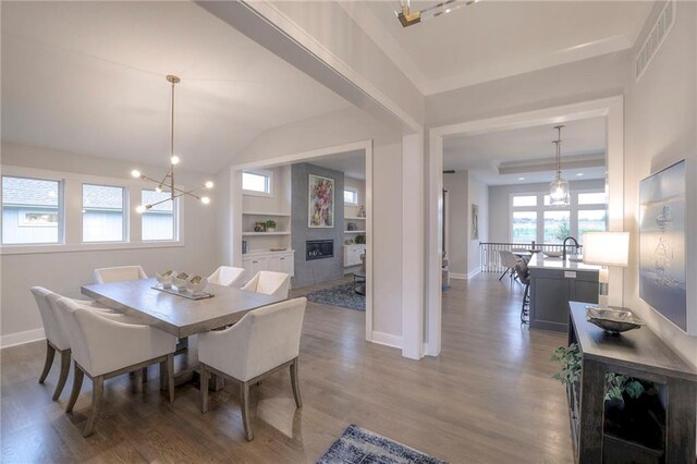 12200 W 138th Pl, Overland Park, KS 66221 - dining area with wood finished floors, a glass covered fireplace, baseboards, and a chandelier