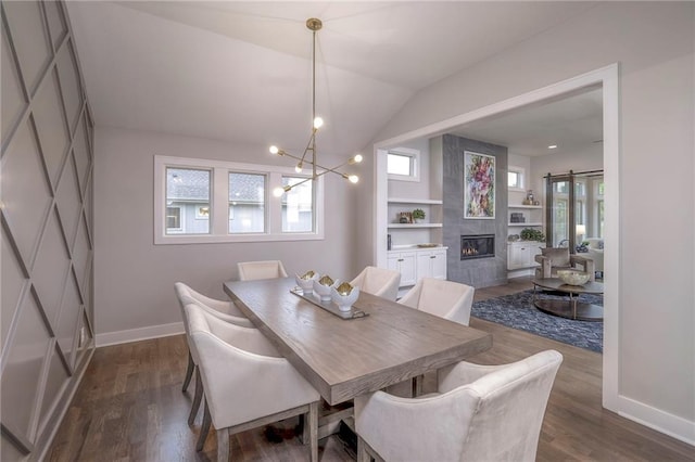 12200 W 138th Pl, Overland Park, KS 66221 - dining space with baseboards, a fireplace, a chandelier, dark wood finished floors, and vaulted ceiling