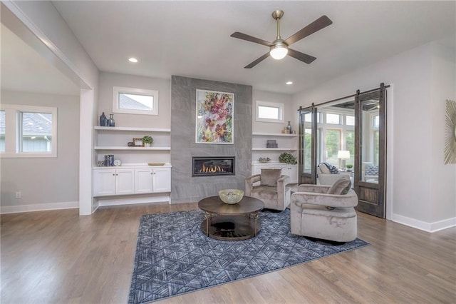 12200 W 138th Pl, Overland Park, KS 66221 - living area featuring baseboards, wood finished floors, recessed lighting, a tile fireplace, and a ceiling fan