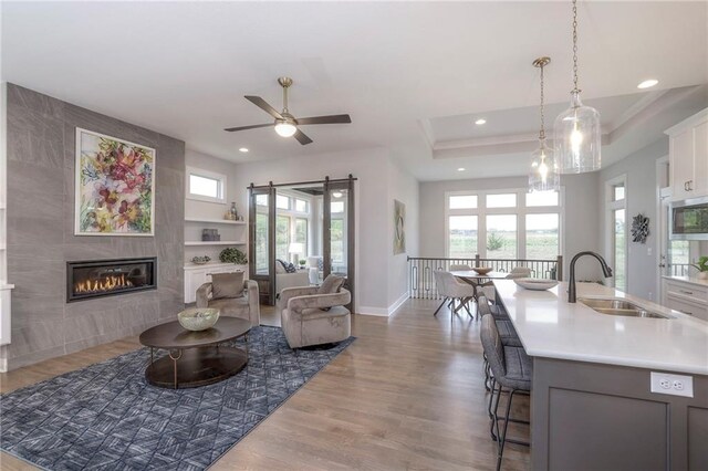 12200 W 138th Pl, Overland Park, KS 66221 - living room with wood finished floors, recessed lighting, baseboards, a tile fireplace, and a ceiling fan