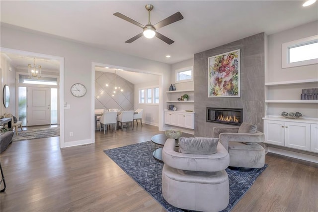 12200 W 138th Pl, Overland Park, KS 66221 - living room featuring built in features, baseboards, a tile fireplace, ceiling fan, and dark wood finished floors