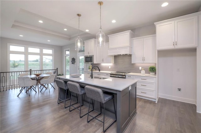 12200 W 138th Pl, Overland Park, KS 66221 - kitchen featuring a sink, appliances with stainless steel finishes, a kitchen bar, dark wood-style flooring, and white cabinets