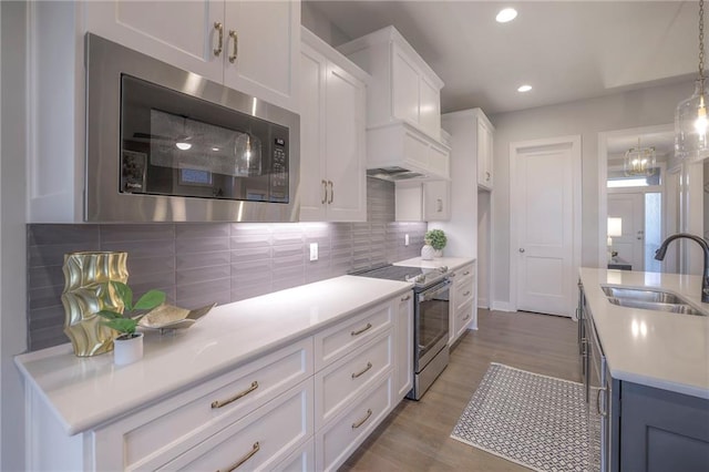 12200 W 138th Pl, Overland Park, KS 66221 - kitchen with stainless steel appliances, a sink, light countertops, white cabinetry, and tasteful backsplash