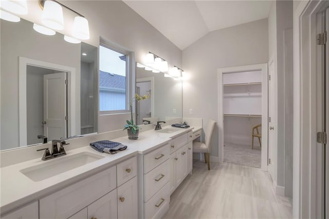 12200 W 138th Pl, Overland Park, KS 66221 - bathroom with double vanity, vaulted ceiling, and a walk in closet