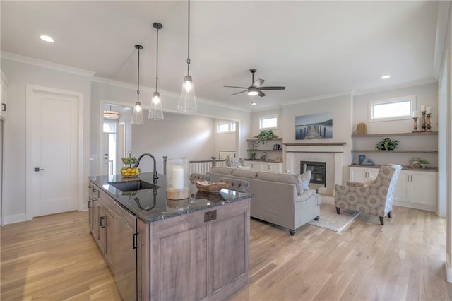 13812 Quigley St, Overland Park, KS 66221 - kitchen with a sink, crown molding, a ceiling fan, light wood-type flooring, and a glass covered fireplace