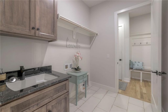 13812 Quigley St, Overland Park, KS 66221 - laundry room featuring washer hookup, cabinet space, light tile patterned floors, and baseboards