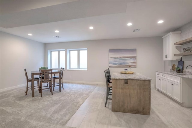 13812 Quigley St, Overland Park, KS 66221 - kitchen featuring recessed lighting, white cabinets, a sink, open shelves, and light stone counters