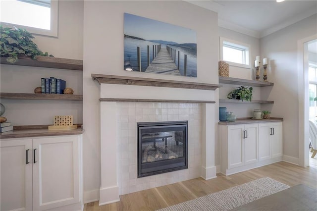 13812 Quigley St, Overland Park, KS 66221 - living area with light wood-style flooring, a tiled fireplace, and baseboards