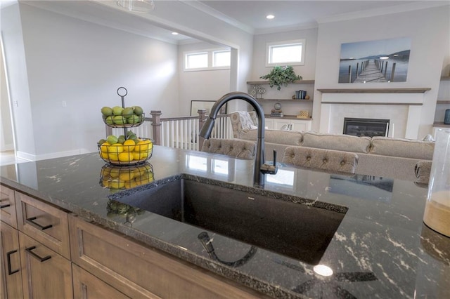 13812 Quigley St, Overland Park, KS 66221 - kitchen view of a sink, crown molding, dark stone counters, a fireplace, and recessed lighting