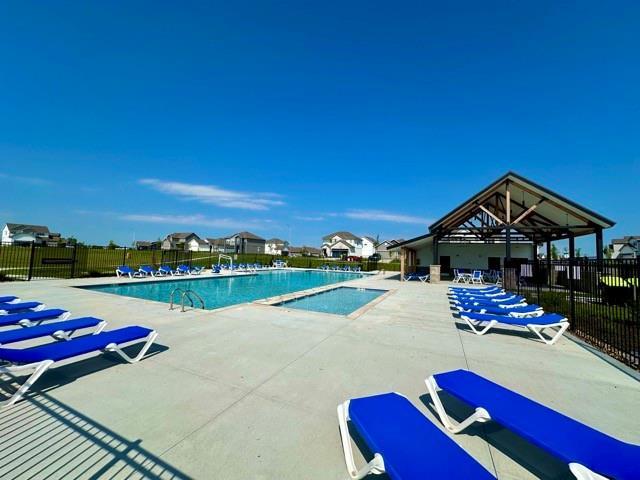 pool with a patio area and fence