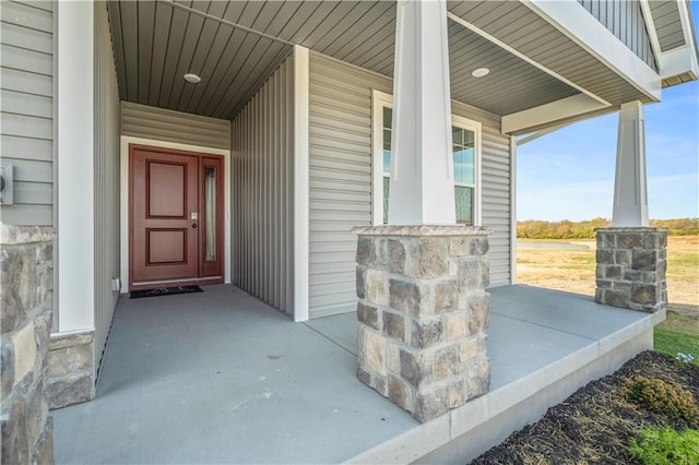 property entrance with stone siding and covered porch