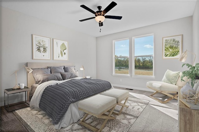 carpeted bedroom featuring visible vents, ceiling fan, and baseboards