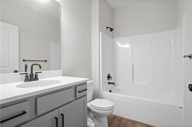 bathroom with toilet, shower / bathtub combination, wood finished floors, and vanity