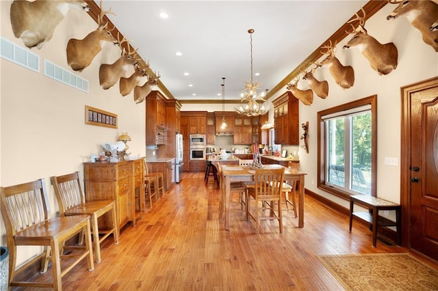 dining area with a chandelier and light hardwood / wood-style flooring