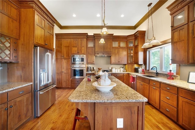 kitchen featuring a kitchen island, light hardwood / wood-style floors, stainless steel appliances, and pendant lighting