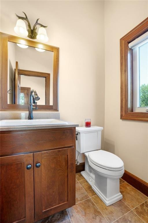 bathroom with tile flooring, toilet, and vanity