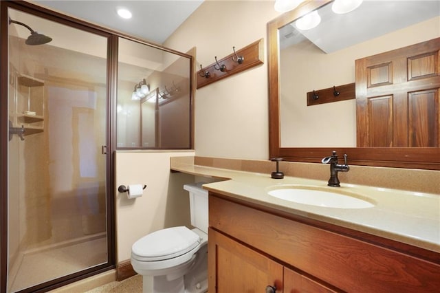 bathroom featuring toilet, a shower with door, and vanity with extensive cabinet space