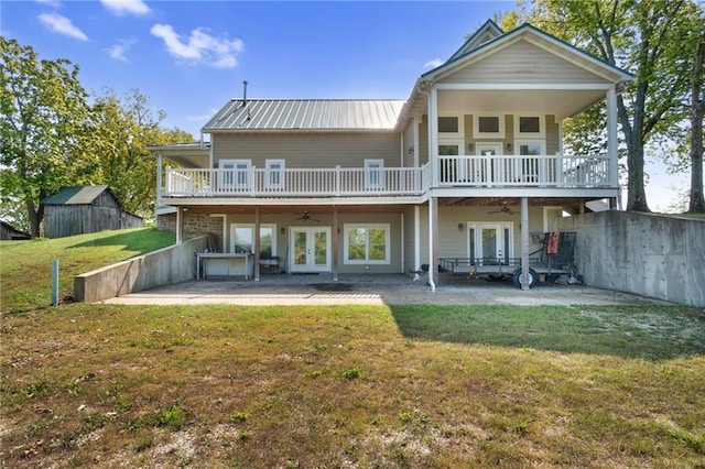 rear view of house featuring a lawn, ceiling fan, french doors, and a patio