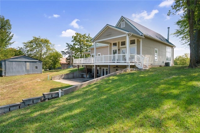 rear view of property with a porch, a storage unit, central air condition unit, and a lawn