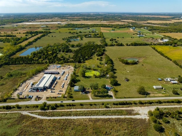 birds eye view of property featuring a water view and a rural view