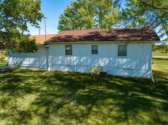 exterior space with central AC unit and a lawn