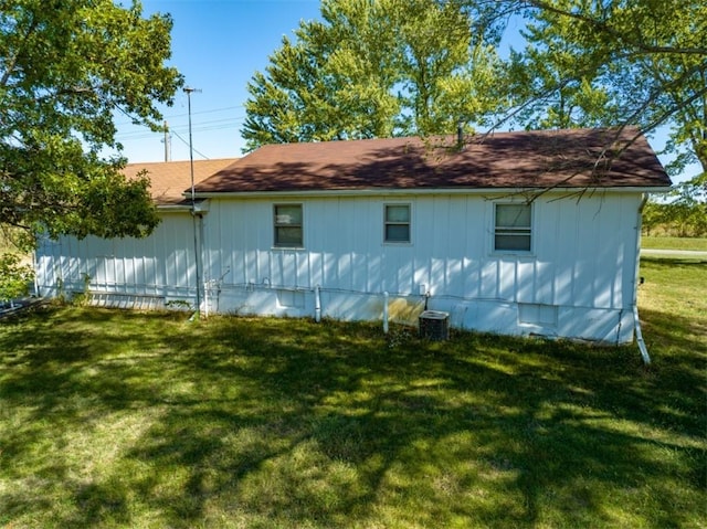 view of side of home with a lawn and central AC unit