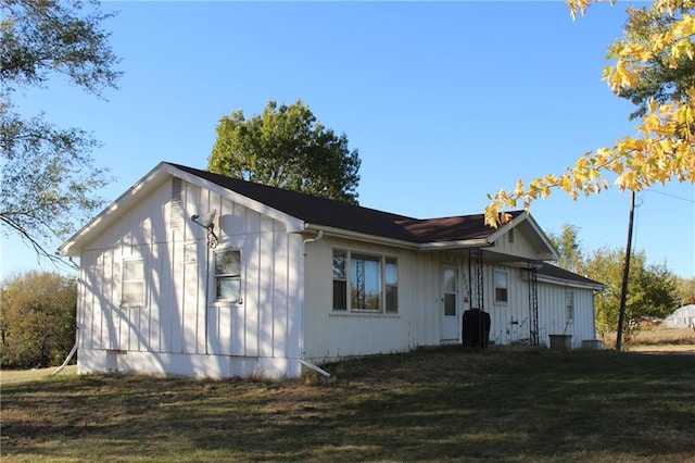 rear view of house featuring a yard