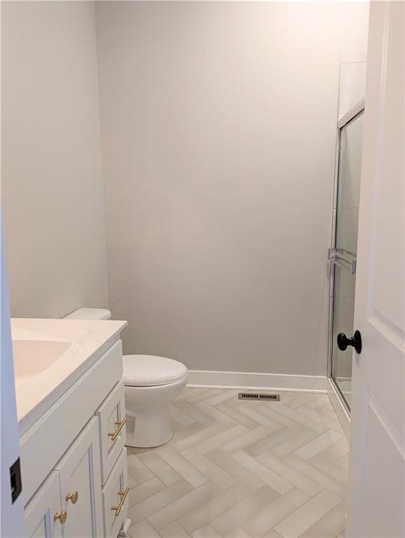 full bathroom featuring toilet, visible vents, vanity, baseboards, and a stall shower