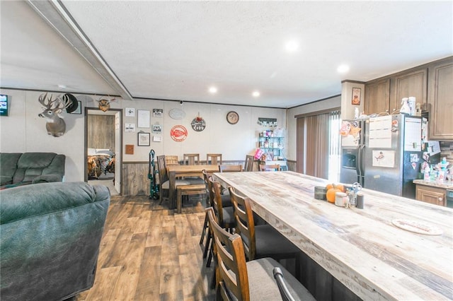 kitchen featuring butcher block countertops, stainless steel fridge with ice dispenser, and hardwood / wood-style floors