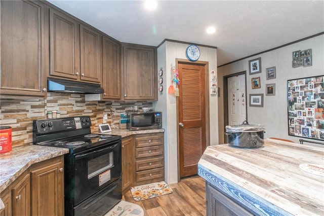 kitchen featuring light hardwood / wood-style floors, butcher block counters, black range with electric cooktop, backsplash, and ornamental molding