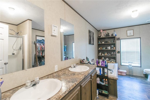 bathroom with oversized vanity, toilet, a shower, and dual sinks