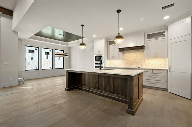 kitchen with wood-type flooring, a kitchen island with sink, and appliances with stainless steel finishes