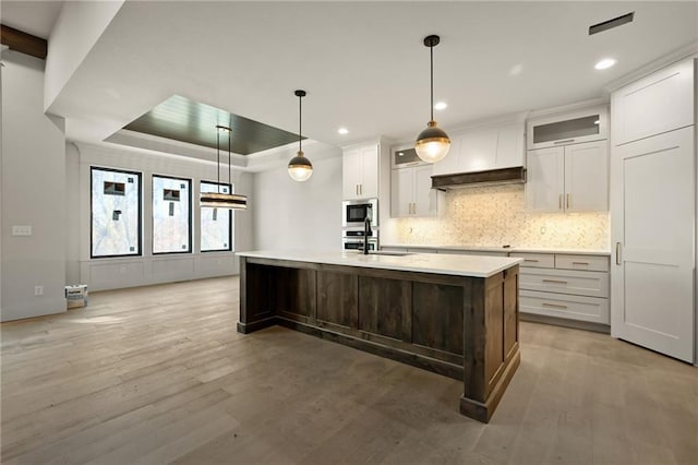111 Teton Rdg, Lake Winnebago, MO 64034 - kitchen with built in microwave, light countertops, light wood-style flooring, backsplash, and recessed lighting