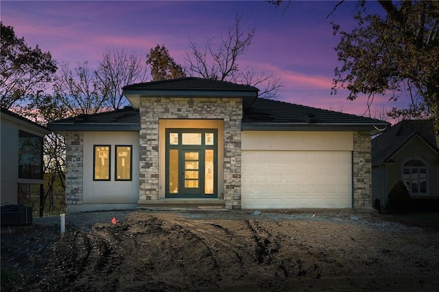111 Teton Rdg, Lake Winnebago, MO 64034 - view of front of house featuring stone siding, an attached garage, driveway, and stucco siding