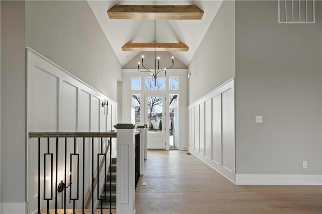 foyer entrance featuring high vaulted ceiling, visible vents, beamed ceiling, and wood finished floors