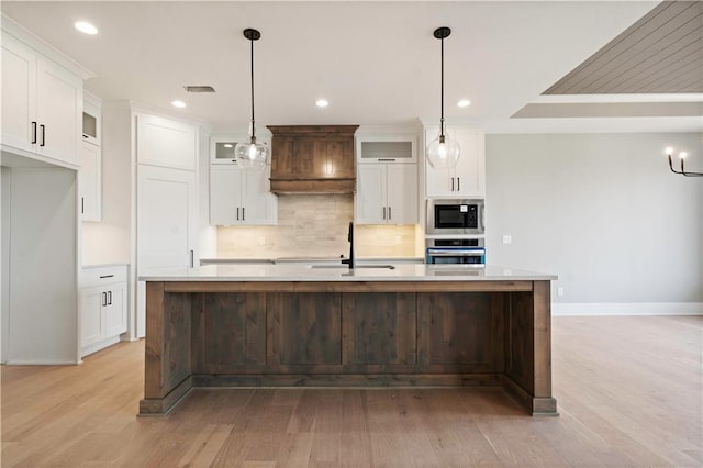 kitchen with tasteful backsplash, light countertops, custom range hood, appliances with stainless steel finishes, and white cabinets