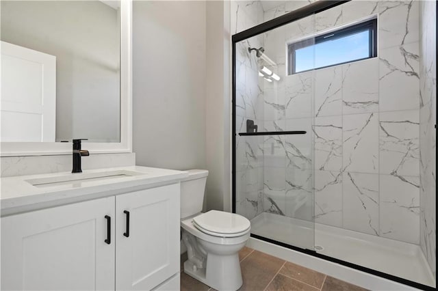 bathroom with toilet, a marble finish shower, and vanity