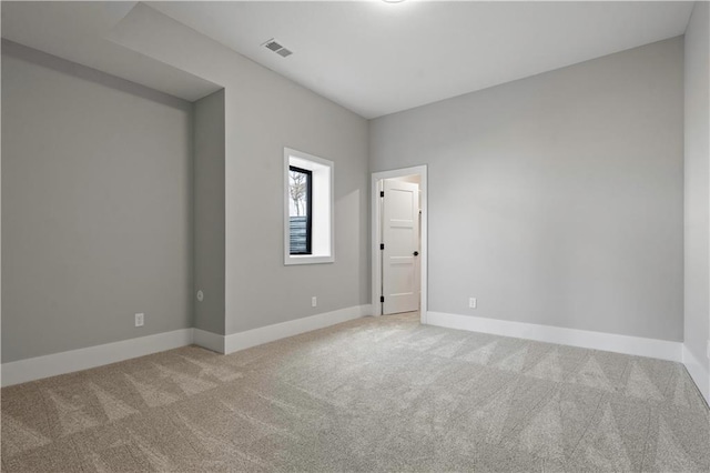 spare room featuring carpet flooring, visible vents, and baseboards