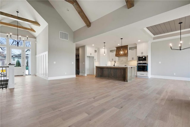 115 Teton Rdg, Lake Winnebago, MO 64034 - unfurnished living room featuring a chandelier, high vaulted ceiling, beam ceiling, light wood-type flooring, and recessed lighting