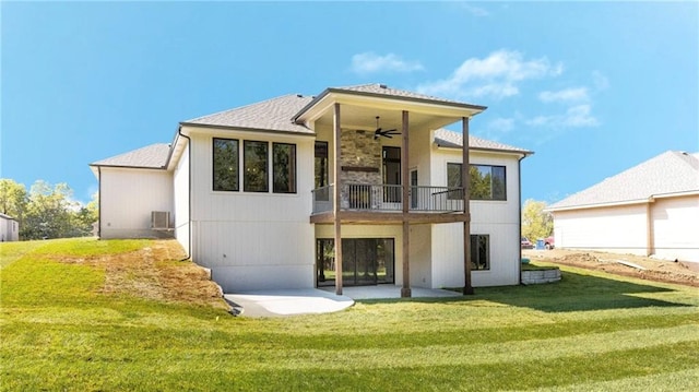 rear view of house featuring a shingled roof, a lawn, a balcony, ceiling fan, and a patio area