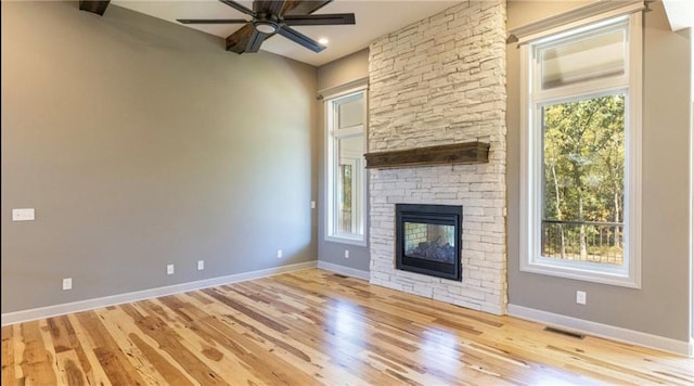 unfurnished living room featuring a wealth of natural light, visible vents, and a fireplace