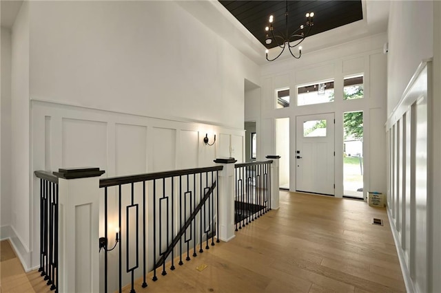 119 Teton Rdg, Lake Winnebago, MO 64034 - foyer featuring a decorative wall, a towering ceiling, hardwood / wood-style flooring, a chandelier, and wainscoting
