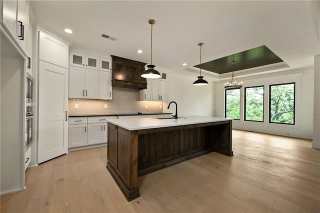 119 Teton Rdg, Lake Winnebago, MO 64034 - kitchen featuring premium range hood, light wood-type flooring, a tray ceiling, backsplash, and recessed lighting