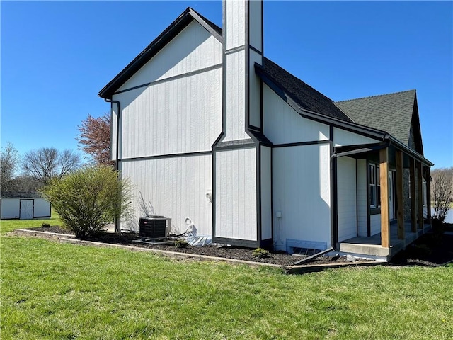 back of property featuring a yard and central AC